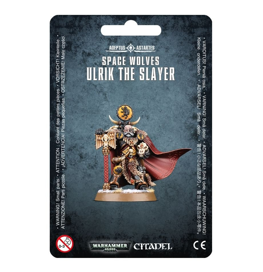 Front of a dark blue-gray blister card displaying the Ulrik the Slayer miniature in black and gold armor, with a red windswept cloak, skull details, and a red staff on a round base. The card reads “SPACE WOLVES” and “ULRIK THE SLAYER.”