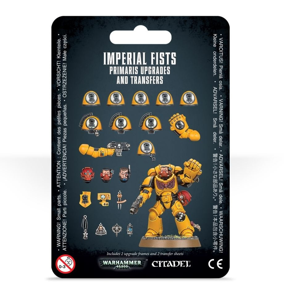 Front of a black hanging package showing a yellow Imperial Fists armored miniature with a raised fist, surrounded by yellow shoulder pads, weapons, heads and other upgrade parts. The title reads “IMPERIAL FISTS PRIMARIS UPGRADES AND TRANSFERS,” with Warhammer 40,000 and Citadel logos along the bottom.