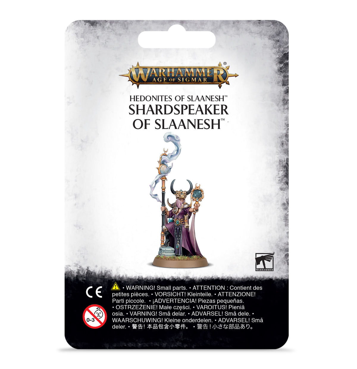 Front of a hanging Warhammer miniature package with a white and gray card and black warning panel. The artwork shows a horned figure in purple robes holding a staff and an ornate object; text reads “WARHAMMER AGE OF SIGMAR” and “SHARDSPEAKER OF SLAANESH.”