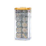 A clear rectangular container with a gold lid holds dark gray dice with gold pips and ornate faction symbols. The front reads “WARHAMMER THE OLD WORLD” and “WARRIORS OF CHAOS DICE SET.”