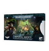 A stack of Imperial Agents index cards shown at an angle, with the front cover depicting masked, armored figures in a green-lit battle scene. The cover reads “WARHAMMER 40,000,” “INDEX,” and “IMPERIAL AGENTS,” with white faction emblems along the bottom.