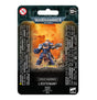 Front of a black card package for a Space Marines Lieutenant miniature, showing a blue-armored figure holding a large firearm against an orange, smoky background. The package reads “WARHAMMER 40,000” and “SPACE MARINES LIEUTENANT,” with 12+ and 0–3 warning symbols.