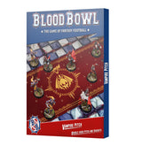 Front of a Blood Bowl Vampire Pitch box, with a red football pitch, gold central emblem, blue-gray stone borders and miniature vampire players on round bases. The box reads “BLOOD BOWL” and “VAMPIRE PITCH,” with the title repeated on its blue spine.