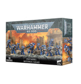 Box for a Space Marines Infernus Squad miniature set, shown from the front and right side. Artwork depicts blue-armored soldiers with long weapons amid orange flames and ruined buildings; the box reads “WARHAMMER 40,000” and “INFERNUS SQUAD.”