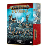A boxed Stormcast Eternals miniature set shown from the front and right side, with gold-and-blue armored fantasy figures and a winged warrior on rocky terrain. The turquoise and red box reads “WARHAMMER AGE OF SIGMAR,” “SPEARHEAD,” and “STORMCAST ETERNALS.”