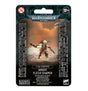 Front of a Warhammer 40,000 miniature package showing a green-skinned warrior with a red feathered crest, layered armor and blades against an orange scene. The packaging reads “WARHAMMER 40,000” and “KROOT FLESH SHAPER.”