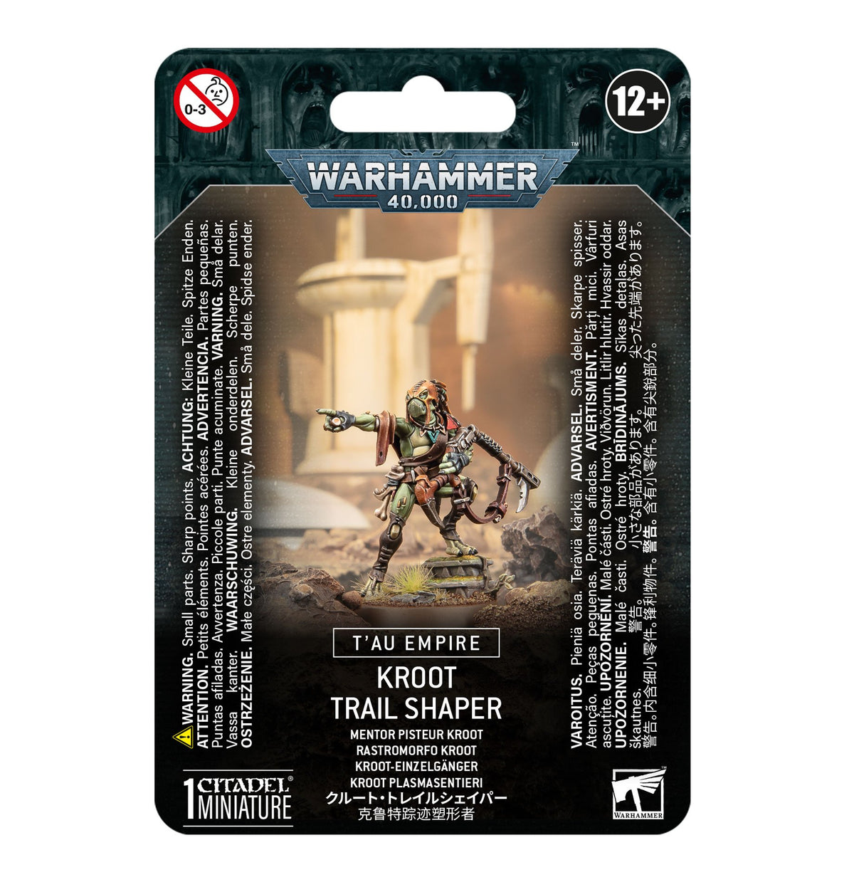 Front of a Warhammer 40,000 blister-card package showing a green and brown Kroot warrior miniature pointing while standing on rocky terrain. The package reads “T’AU EMPIRE” and “KROOT TRAIL SHAPER.”