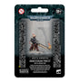 Front of a Warhammer 40,000 miniature package, with a dark teal and black backing and a small armored figure in brown robes holding a long weapon with a flame at its tip. The packaging reads “WARHAMMER 40,000” and “MINISTORUM PRIEST WITH VINDICTOR.”