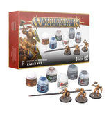 Warhammer Age of Sigmar Stormcast Eternals paint set shown with its red-and-white box, six paint pots, a brush and three gold-armored miniatures on round bases. The box reads “WARHAMMER AGE OF SIGMAR” and “STORMCAST ETERNALS PAINT SET.”
