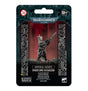 Front of a dark teal and black Warhammer 40,000 package, with a masked miniature in dark armor holding a long rifle against a red backdrop. The card reads “IMPERIAL AGENTS” and “VINDICARE ASSASSIN,” with “12+” at the top.
