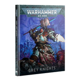 Hardback book shown at an angle revealing the spine and front cover of Codex: Grey Knights. The cover art depicts an armored warrior in silver-teal power armor wielding a hammer with a glowing blue blade and a flaming gauntlet, standing over daemonic figures on a purple-blue background, with the "WARHAMMER 40,000" logo at top and "CODEX GREY KNIGHTS" at the bottom; the spine reads "CODEX: GREY KNIGHTS".