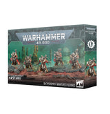 Product box for the Warhammer 40,000 kit "ADEPTUS MECHANICUS HASTARII", shown at a three-quarter angle revealing the front and side panels. The front artwork depicts five heavily armoured silver-and-red miniatures with cloaks standing on rocky reddish terrain against a teal-green backdrop, beneath the "WARHAMMER 40,000" logo and the label "5 CITADEL MINIATURES/FIGURINES".