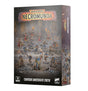 Box for the Necromunda: Cawdor Underhive Crew miniature set, showing painted figures in red and blue robes wielding guns, torches and banners on a rubble-strewn floor. The top reads "WARHAMMER NECROMUNDA" and the bottom "CAWDOR UNDERHIVE CREW" beside a "16 CITADEL MINIATURES" badge and Warhammer logo.