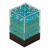 A clear square container holds translucent teal six-sided dice with white pips, stacked above a black base. Teal labels on the front read “CHX23815” and “CHESSEX.”