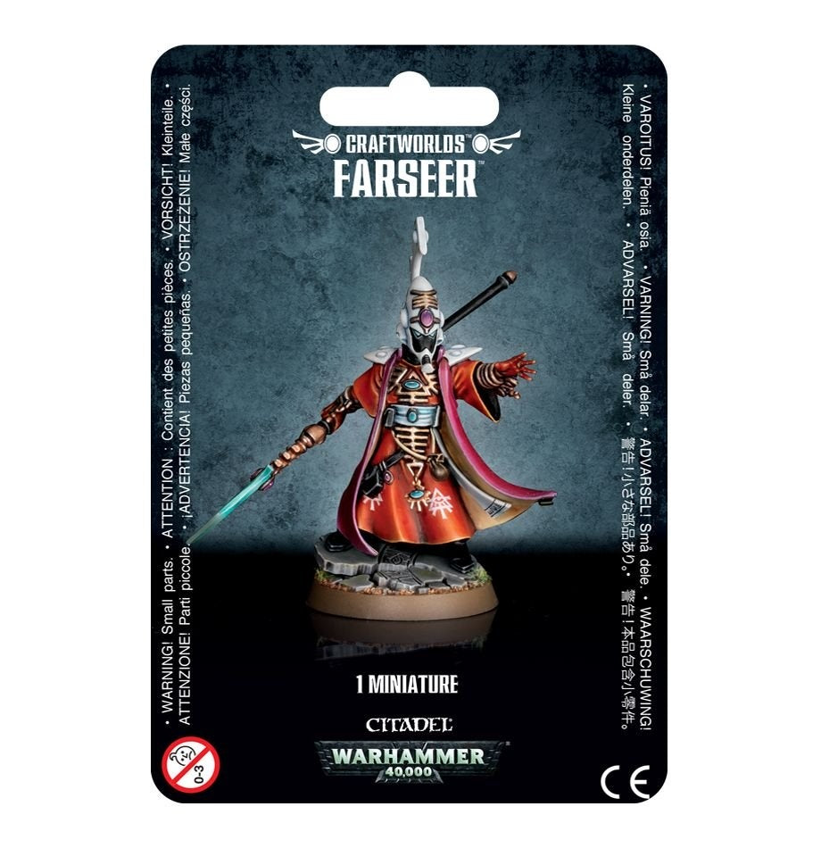 A packaged Aeldari Farseer miniature stands on a round base, wearing red-orange robes, a purple-trimmed cape and an ornate helmet, with a teal spear and one arm extended. The card reads “CRAFTWORLDS FARSEER” and “1 MINIATURE.”