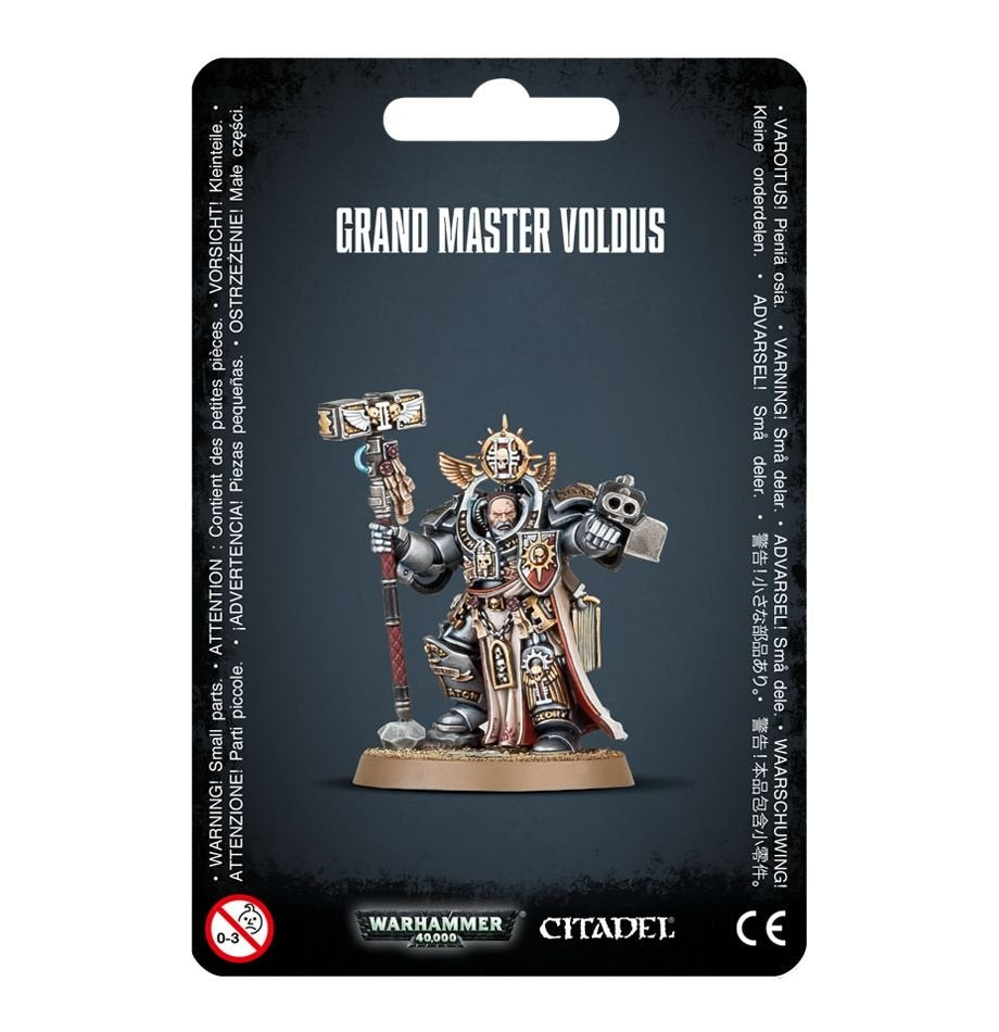 Front of a black-backed package displaying an armored Grey Knights miniature in silver and gray with gold details and red accents, holding a hammer and a large weapon. The card reads “GRAND MASTER VOLDUS” above the figure, with “WARHAMMER 40,000” and “CITADEL” logos below.