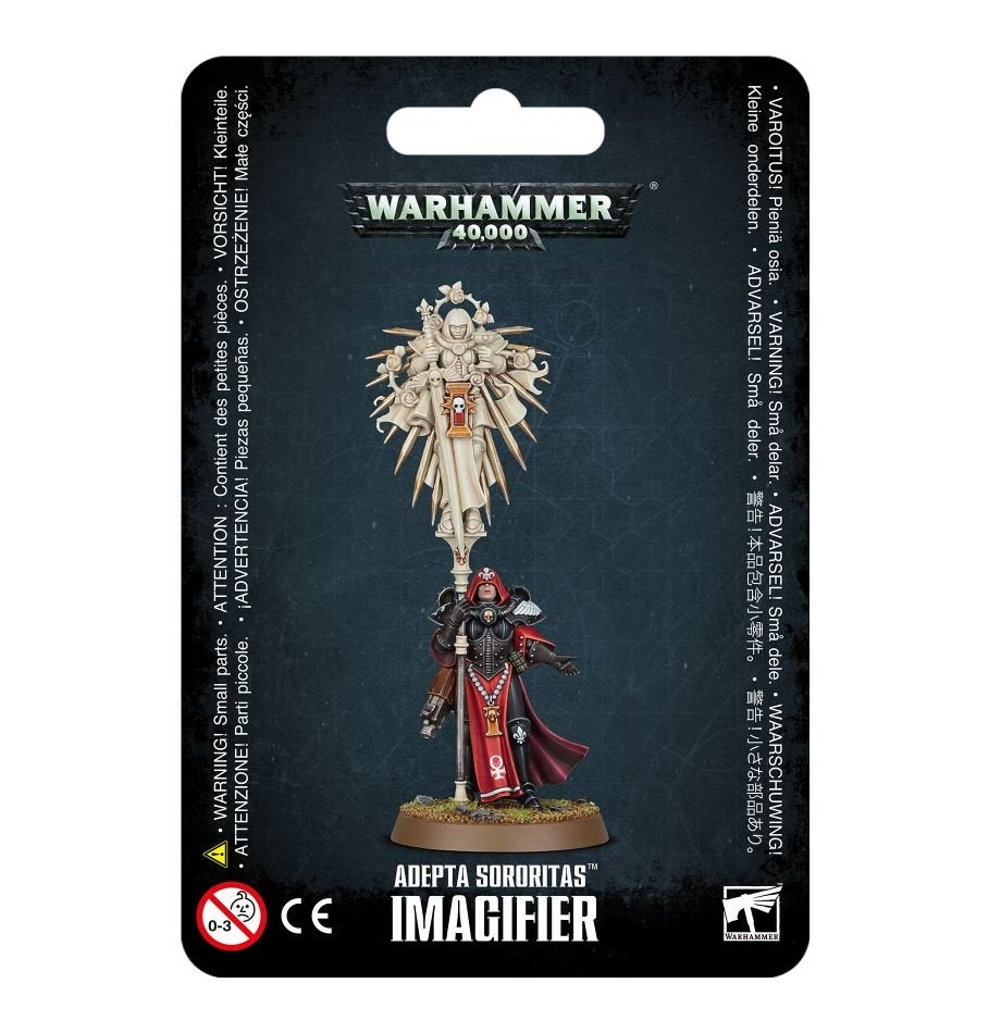 Packaged Adepta Sororitas miniature in black and red armor, standing beneath a tall ivory-colored effigy of a saint on a stanchion. The dark backing reads “WARHAMMER 40,000” and “ADEPTA SORORITAS IMAGIFIER.”