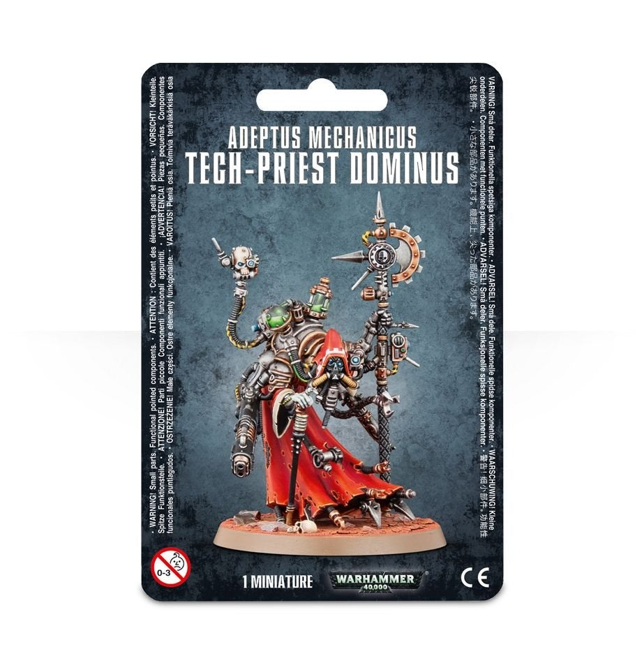 Front of a dark blue-black package for an Adeptus Mechanicus Tech-Priest Dominus miniature, showing a hooded mechanical figure in silver armor, a red robe and green lenses on a round base. The card reads “ADEPTUS MECHANICUS TECH-PRIEST DOMINUS” and “1 MINIATURE.”