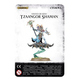Front of a Citadel miniature package labeled “TZAANGOR SHAMAN,” showing a horned, armored figure in blue and turquoise holding a staff atop a dark, spiked disc, suspended over a grassy base by a curling green magical plume.
