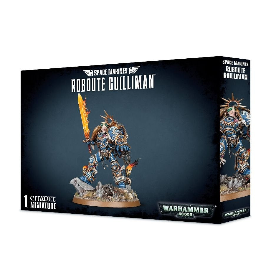 Box for a Space Marines: Roboute Guilliman miniature, with a painted blue-and-gold armored figure holding a flaming sword and standing on a rocky base. The front reads “SPACE MARINES” and “ROBOUTE GUILLIMAN”; the narrow side shows another view of the figure.
