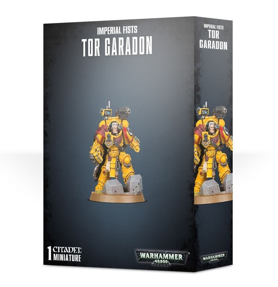 Black box showing a yellow-armored Tor Garadon miniature with red shoulder cloth, standing on a round base among gray rubble; the front and right side repeat the figure. Text reads “IMPERIAL FISTS,” “TOR GARADON,” and “WARHAMMER 40,000.”