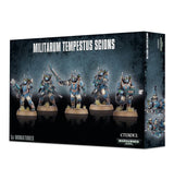 A black-and-blue miniature box shows five helmeted sci-fi soldiers in blue-gray armor holding weapons, standing on round bases. The front reads “MILITARUM TEMPESTUS SCIONS” and “5x MINIATURES,” with a narrow side panel also visible.