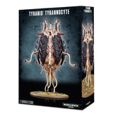 Tyranid Tyrannocyte miniature shown on the front and side of a dark game box, with a pale, fleshy body, dark purple armor plates, raised spines and dangling tentacles on a round base. The box reads “TYRANID TYRANNOCYTE” and “1 MINIATURE.”