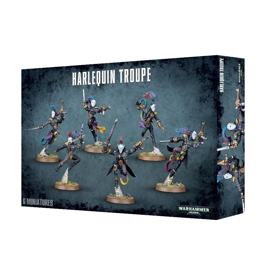 Angled Harlequin Troupe miniature box showing six masked, brightly patterned figures in dynamic poses with weapons on round bases; the front reads “HARLEQUIN TROUPE” and “6 MINIATURES,” with part of the box side visible.