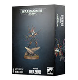 Black Warhammer 40,000 box showing Drazhar, an armored miniature with dark, gold and red details, standing on a sculpted base; part of the figure artwork continues onto the narrow side panel. The box reads “WARHAMMER 40,000” and “DRAZHAR.”