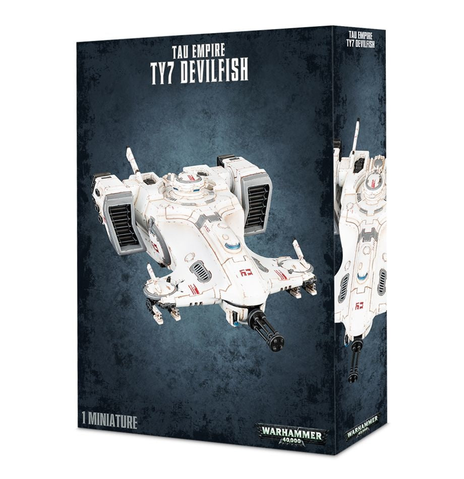 Dark mottled box showing a white, gray-detailed sci-fi Tau Empire TY7 Devilfish vehicle with side pods and a forward gun; the narrow side panel shows another view. Text reads “TAU EMPIRE TY7 DEVILFISH” and “1 MINIATURE.”