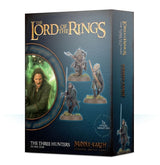 Box for The Three Hunters miniature set, shown from the front and right side. The dark blue-green front features three armed figures on round bases and a circular character portrait, with gold text “THE LORD OF THE RINGS” and “MIDDLE-EARTH”; the side repeats the artwork and title.