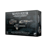 A dark charcoal box with blue technical-grid graphics shows three sci-fi weapons on the front and a narrow side panel with weapon artwork. The box reads “WARHAMMER THE HORUS HERESY” and “HEAVY WEAPONS UPGRADE SET.”