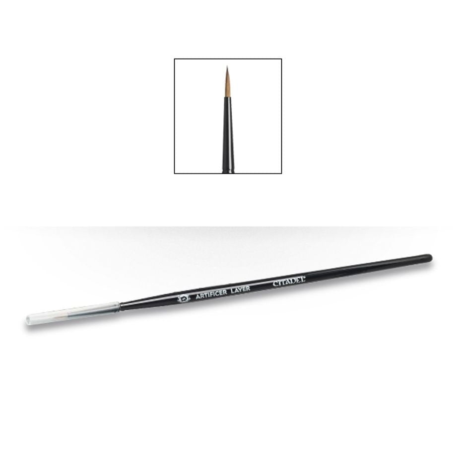 A slender black Citadel Artificer Layer brush lies diagonally, with a clear protective cap over one end and fine pointed brown bristles at the other. The handle reads “ARTIFICER LAYER” and “CITADEL”; an inset shows a close-up of the pointed tip.