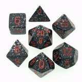 Seven dark gray polyhedral dice are arranged separately on a white background. Each has white and gray speckles and red numerals, with different shapes including a cube and several multi-sided dice.