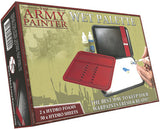 Box for a wet palette showing an open red tray with raised channels beside a black case, white sheet, paint bottles and a hand painting. The front reads “THE ARMY PAINTER” and “WET PALETTE.”