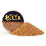 A small round container of fine tan-brown basing grit sits behind a loose mound of the same granular material. The dark blue label features yellow lettering reading “GaleForce nine” and “HOBBY SCENICS.”