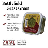 Clear rectangular tub of fine green flock shown at an angle, with a red-and-olive label and grass graphic. The image reads “Battlefield Grass Green” and shows The Army Painter logo, plus two check-marked use notes.