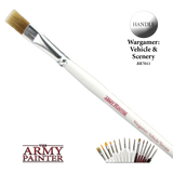 A flat brush with tan bristles, a silver ferrule and a long white handle lies diagonally on a black background; the handle reads “THE ARMY PAINTER” and “Wargamer: Vehicle/Terrain.” A circular “HANDLE” label, brand logo and small lineup of brushes appear below.