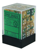 Gold and green six-sided dice with white pips are stacked inside a clear plastic cube with a black base. A green label on the front reads “CHX 26825” and includes a small-parts warning.