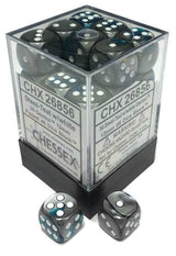 A clear square box packed with dark steel-teal and black six-sided dice with white and teal pips, with two matching dice displayed in front. The box label reads “CHESSEX” and “Steel-Teal/White.”