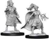 Two gray, unpainted female sorcerer miniatures stand on black round bases against a white background. One wears a patterned skirt and cape; the other has a flowing cape and holds a sculpted magical effect in an outstretched hand.