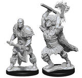 Two unpainted gray male Goliath barbarian miniatures stand on black bases against a white background: one crouches holding a weapon across his body, while the other raises a large axe overhead and wears a fur pelt.