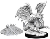 Unpainted gray miniature of a winged red dragon wyrmling rearing on a rocky oval base, shown beside a separate mound of tiny treasure with coins, gems, and a crown.
