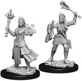 Two gray, unpainted female human cleric miniatures stand on separate black bases. One wears layered robes and holds an ornate staff; the other wears armor and a skirt, carrying a shield and raising an ornate weapon.
