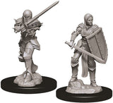 Two unpainted gray female human fighter miniatures stand on rocky bases with black round stands. The left figure wears heavy armor and raises a long sword; the right wears layered armor and holds a large shield and sword.