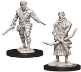 Two unpainted gray male human rogue miniatures on black oval bases: one stands with daggers in both hands, while the other wears a scarf and holds a curved bow and arrow. Both have detailed layered clothing and gear.