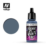 A blue-gray paint bottle with a black dropper cap stands beside a matching round color swatch. Its black-and-purple label reads “GAME Air” and “vallejo,” with “Sombra 72.748” on the narrow band near the neck.