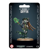 Black hanging package card showing a silver-and-green skeletal Cryptek miniature holding a green staff, with bronze segmented robes and a clawed mechanical mount on a round base. The card reads “NECRONS,” “CRYPTEK,” and “WARHAMMER 40,000.”