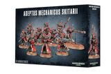 Box for Adeptus Mechanicus Skitarii miniatures, showing a group of red and metallic armored figures with weapons on bases across the front and one figure on the narrow side panel. The front reads “ADEPTUS MECHANICUS SKITARII” and “10 MINIATURES.”
