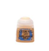 A small paint pot with a rounded white flip-top cap and a gold-colored label with blue splashes. The label reads “CITADEL,” “LAYER,” and “AURIC ARMOUR GOLD.”
